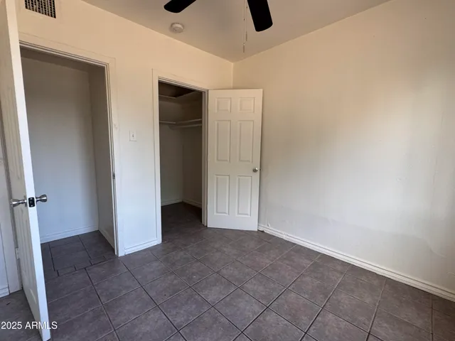 an empty room with windows and fan