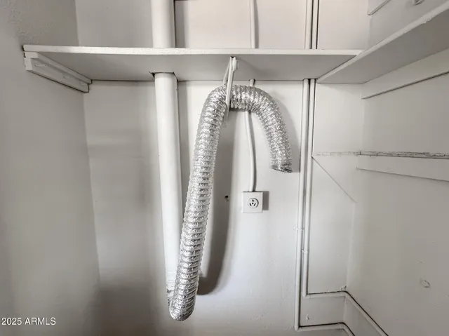 a view of walk in closet with clothes and window