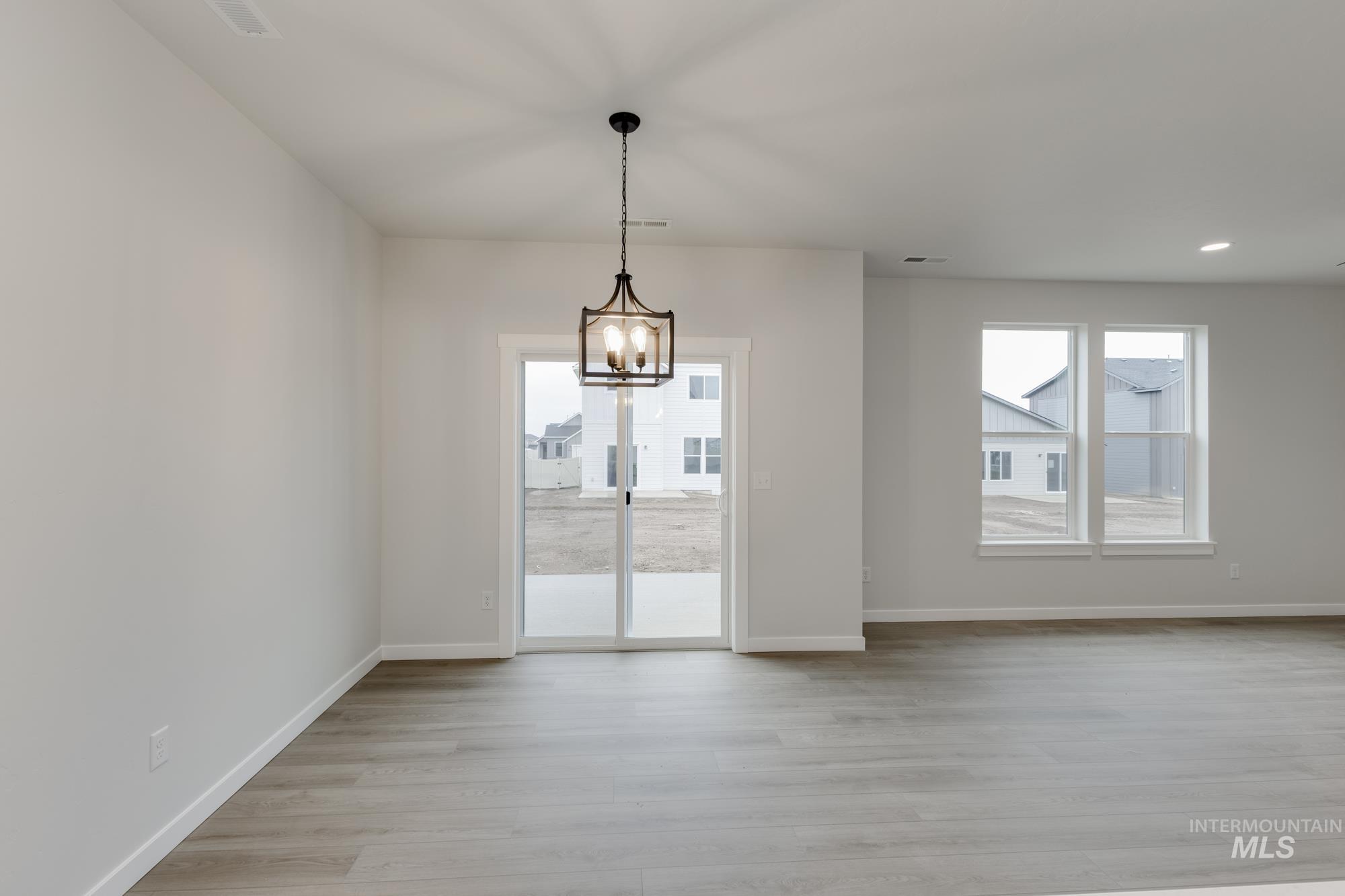 2086 South Border Way Meridian, ID 83642 - Photo 6 of 19 Unfurnished dining area with light wood-type flooring and hanging lights