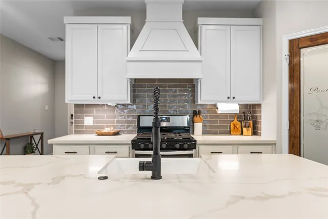 a kitchen with stainless steel appliances a stove a sink and a cabinets