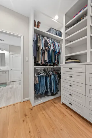 a view of walk in closet with clothes and shoes