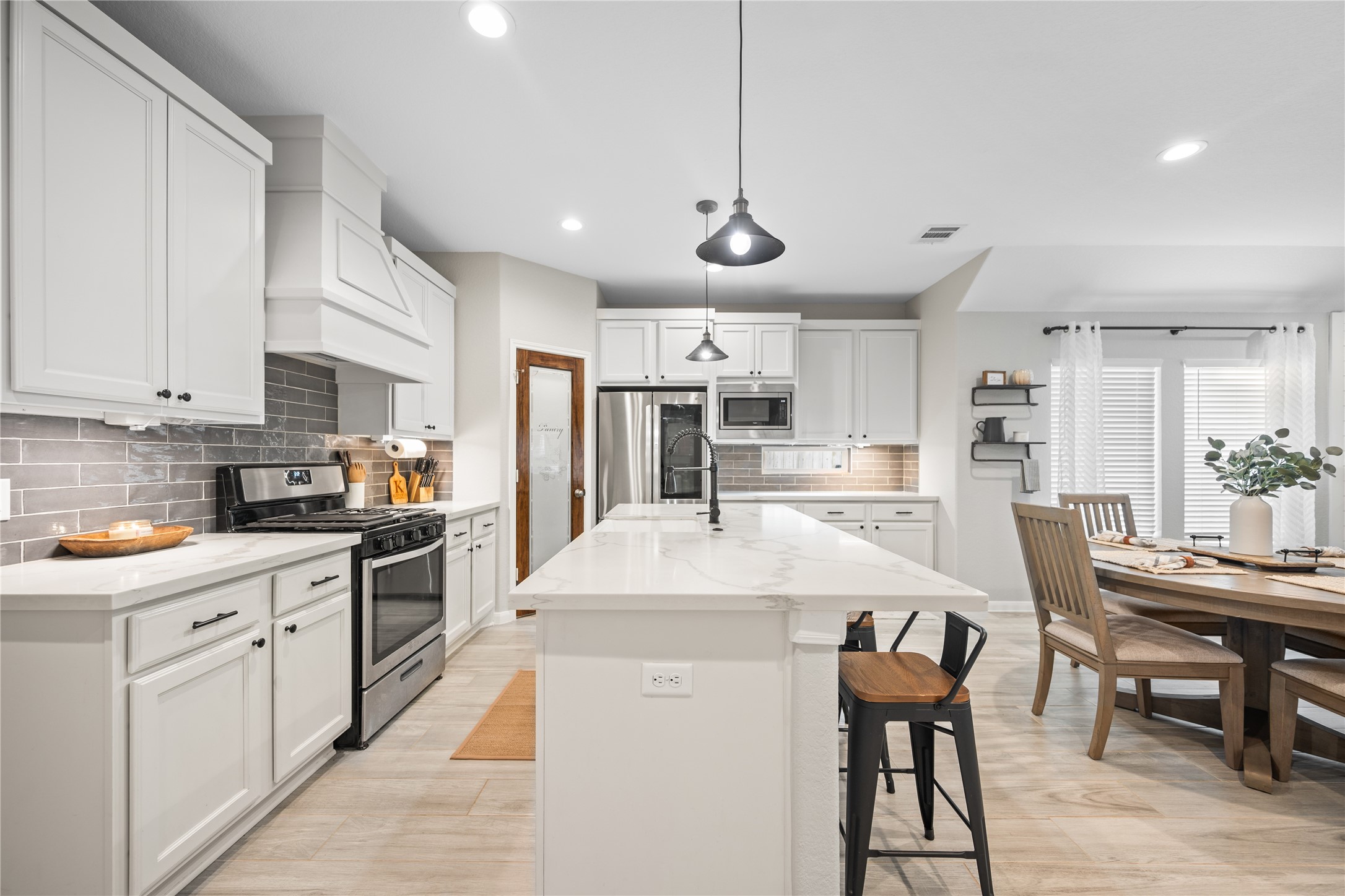 2504 Hagerman Road Conroe, TX 77384 - Photo 10 of 50 a large kitchen with lots of counter space a sink appliances and a dining table