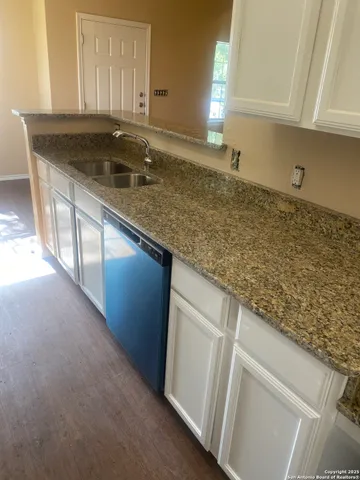 a kitchen with granite countertop sink and cabinets