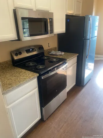 a kitchen with granite countertop a stove and a refrigerator