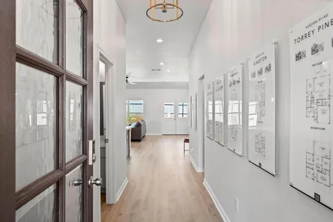 a view of a hallway with wooden floor and staircase