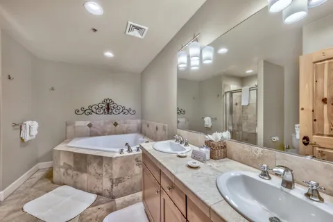 a bathroom with a tub a sink and glass door shower