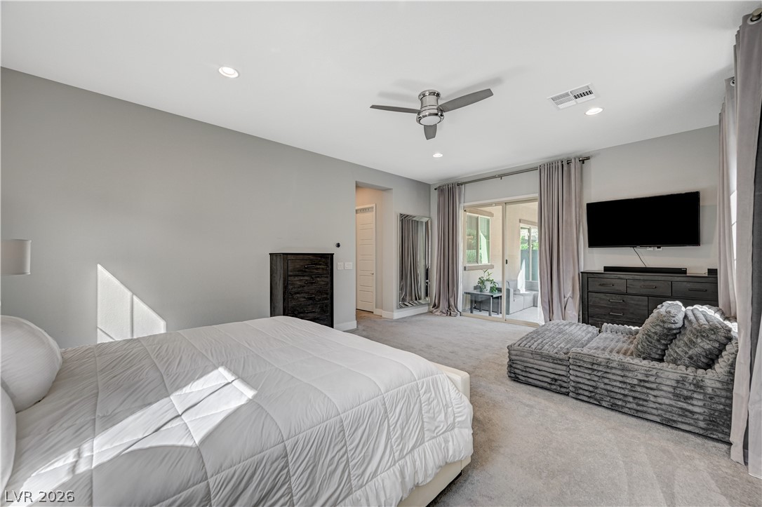 3943 Reyes Avenue Las Vegas, NV 89141 - Photo 40 of 95 An inviting bedroom with plush carpet and direct access to an outdoor retreat through sliding glass doors.
