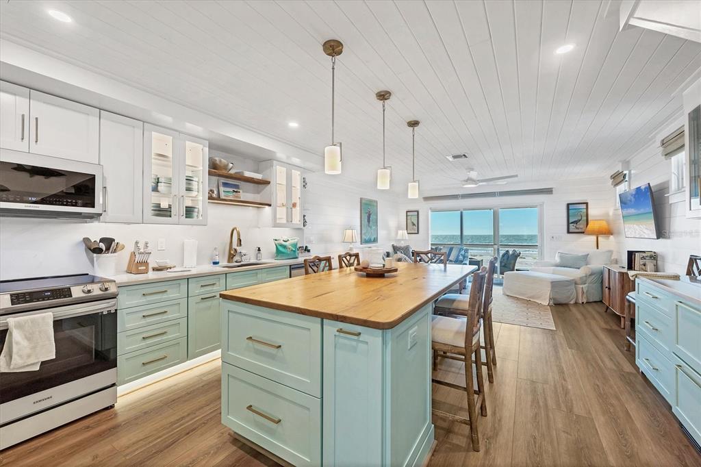 290 Gulf Boulevard, Unit 17 Boca Grande, FL 33921 - Photo 15 of 39 a kitchen with a sink stove and wooden cabinets