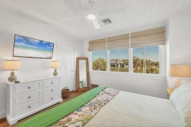 a bedroom with a bed and a dresser next to a window