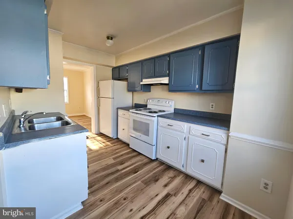 a kitchen with sink cabinets and wooden floor