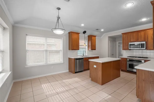 a kitchen with stainless steel appliances a stove sink and microwave