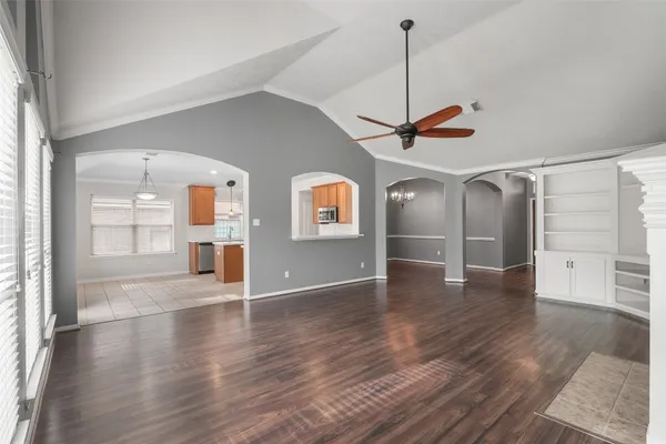 an empty room with a chandelier fan and closet area