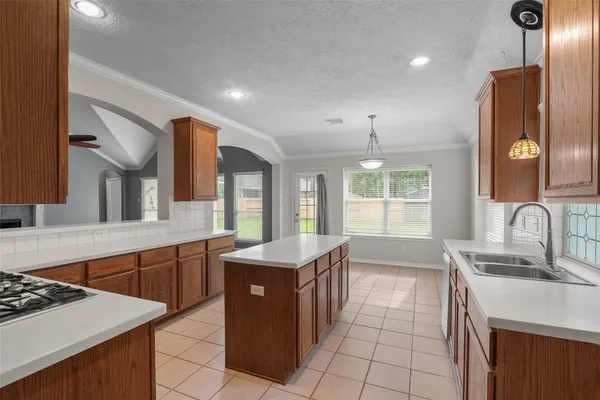 a kitchen with stainless steel appliances granite countertop a stove a sink a refrigerator and a wooden cabinets