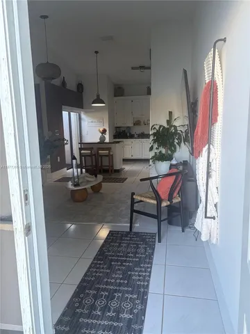 a living room with stainless steel appliances furniture a rug and a window