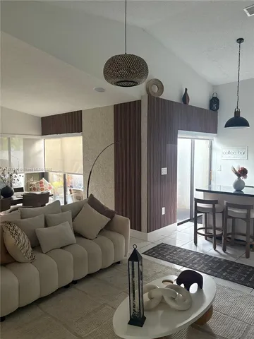 a living room with furniture a window and kitchen view
