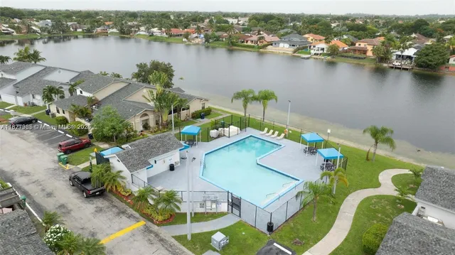 an aerial view of a house with a swimming pool and lake view