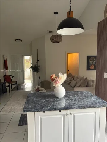 a kitchen with a granite countertop sink a counter top space and cabinets