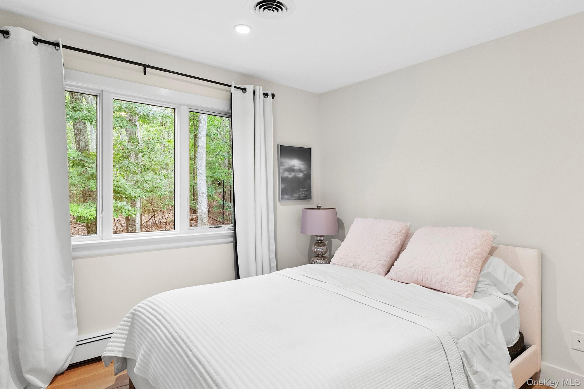 2723 Deerfield Road Sag Harbor, NY 11963 - Photo 12 of 22 a bedroom with a large bed and a window