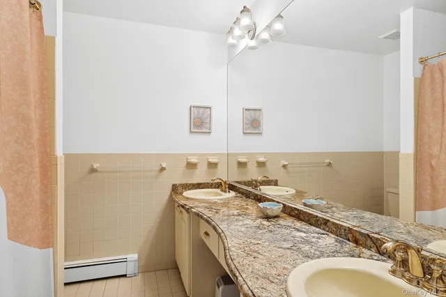 a bathroom with a granite countertop sink a mirror and a shower