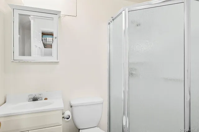 a bathroom with a toilet sink vanity and mirror