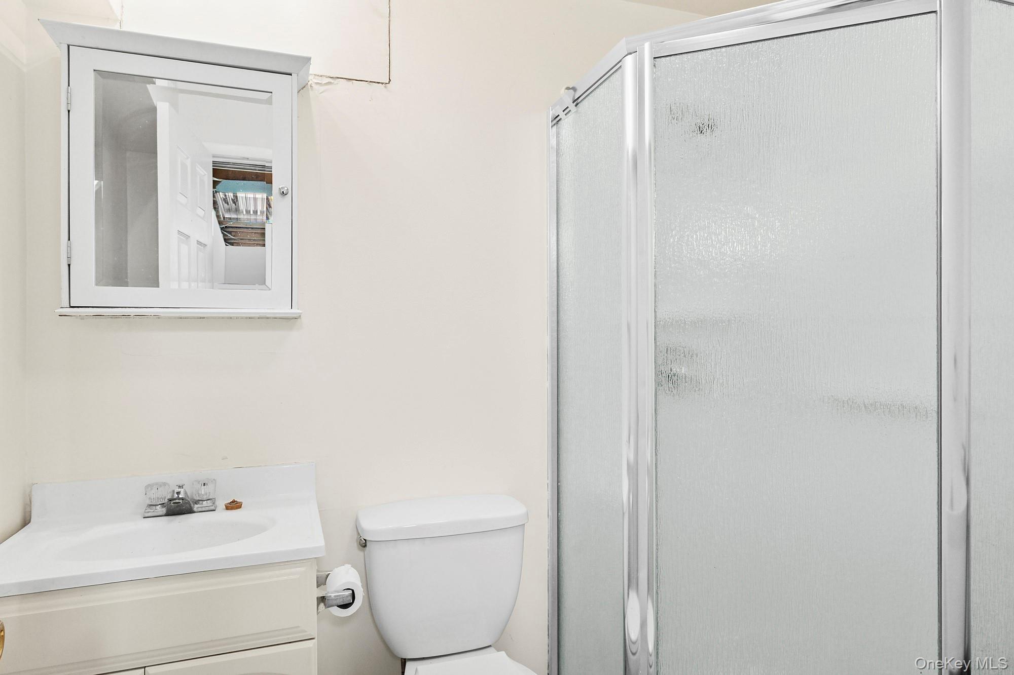 2723 Deerfield Road Sag Harbor, NY 11963 - Photo 19 of 22 a bathroom with a toilet sink vanity and mirror