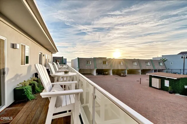 a view of a balcony with chairs and wooden floor