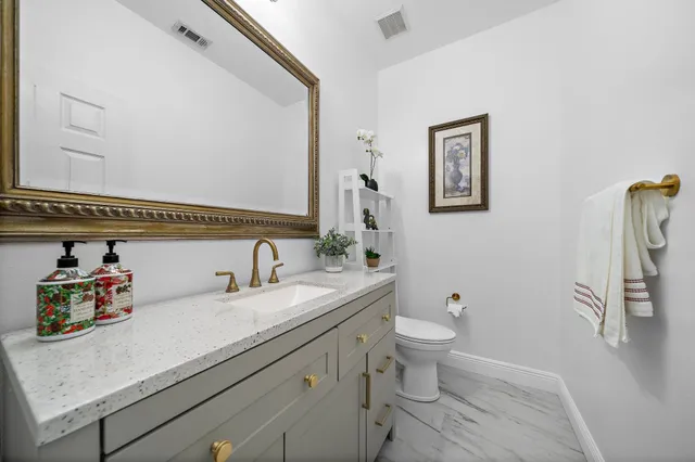 a bathroom with a sink a toilet and a mirror