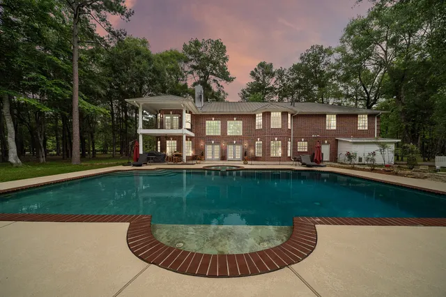 a view of a house with a swimming pool and a yard