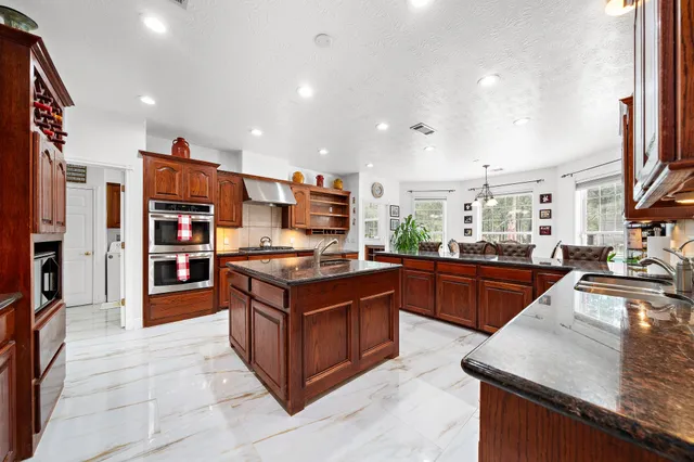 a kitchen with stainless steel appliances granite countertop a stove and a refrigerator