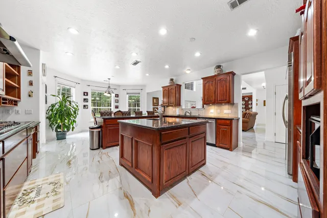 a kitchen with stainless steel appliances granite countertop a stove a sink dishwasher a oven and a refrigerator