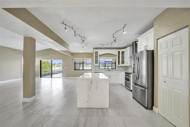 a kitchen with stainless steel appliances granite countertop a refrigerator and microwave