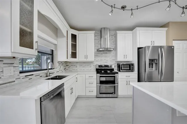 a kitchen with cabinets stainless steel appliances and sink