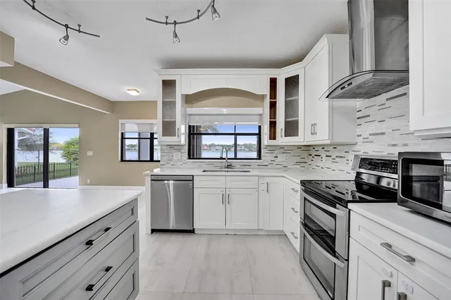 a kitchen with stainless steel appliances granite countertop a stove and cabinets