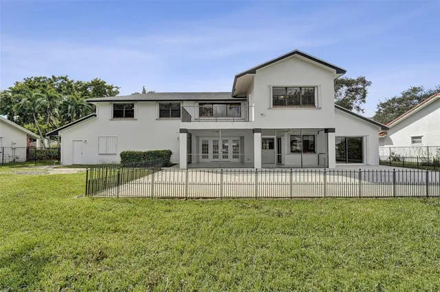 a view of house with a big yard and large trees