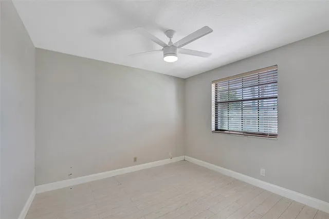 a view of a hallway with wooden floor and windows