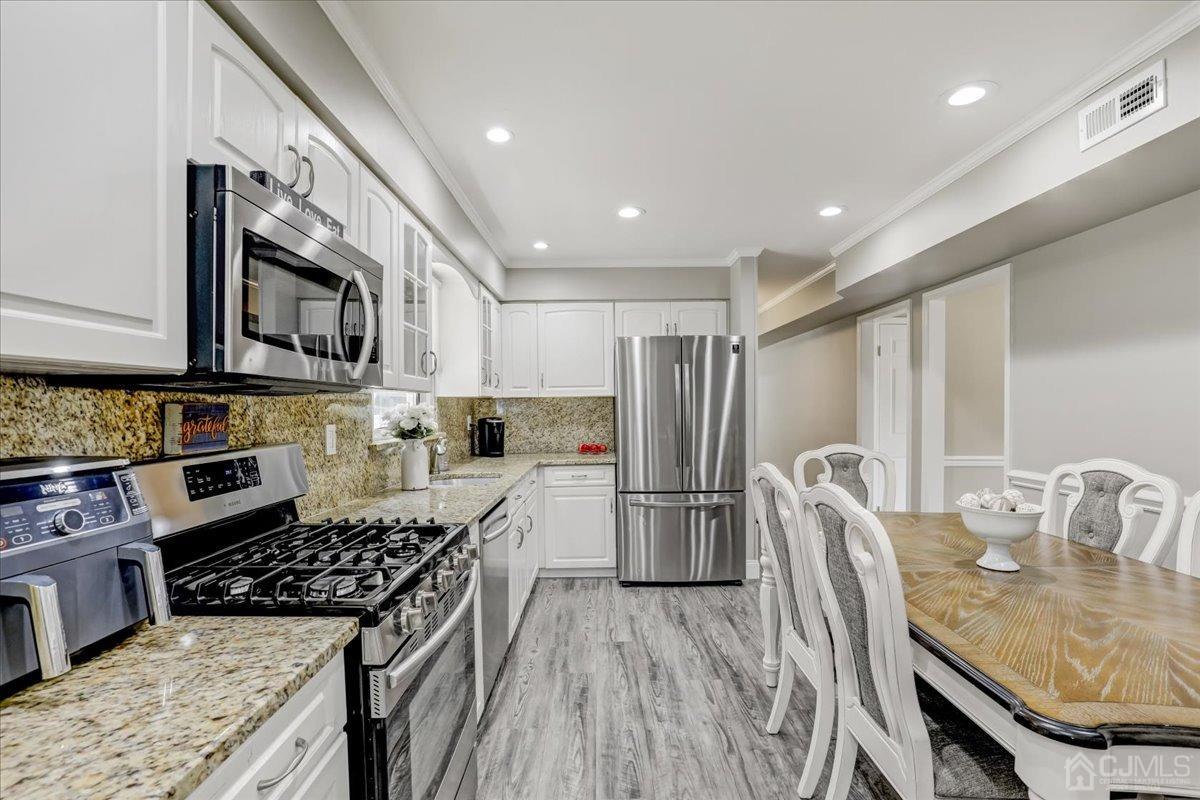 10 William Way Old Bridge, NJ 07747 - Photo 8 of 33 a kitchen with stainless steel appliances granite countertop a stove top oven a refrigerator a sink and a stove