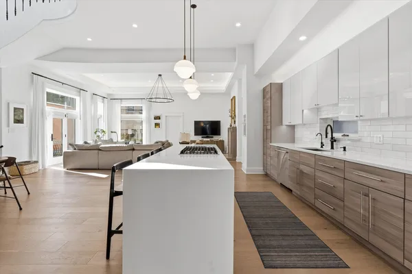 a large white kitchen with lots of counter space a sink and appliances