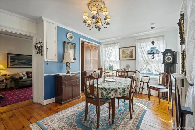 a view of a dining room with furniture a chandelier and wooden floor
