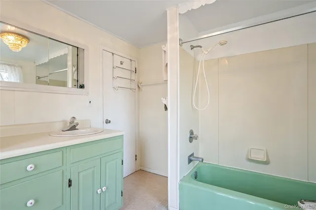 a bathroom with a granite countertop sink a mirror a shower and a bathtub