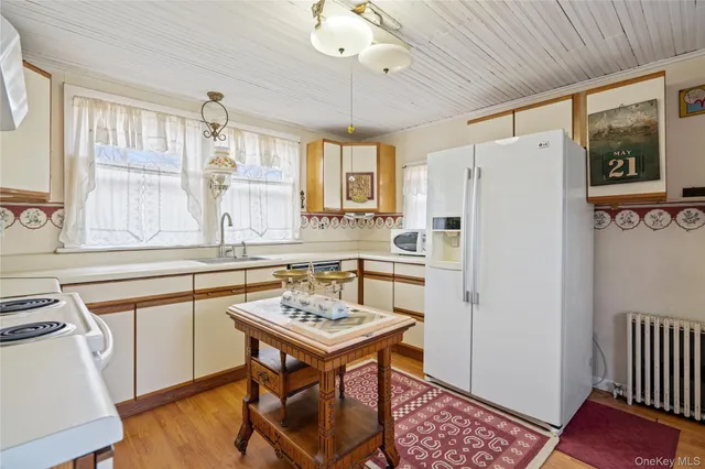a kitchen with refrigerator cabinets and wooden floor