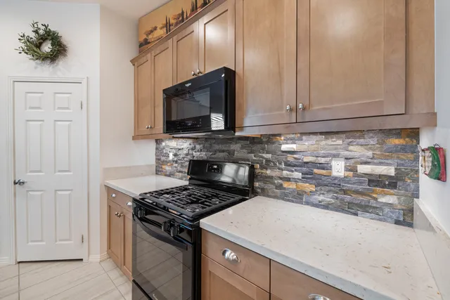 a kitchen with granite countertop a stove and cabinets
