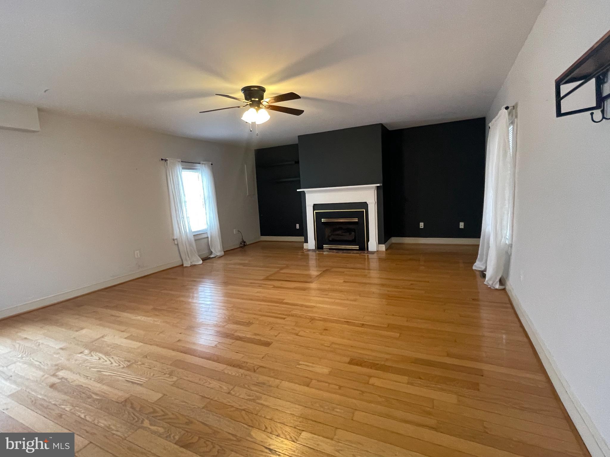 33 Crookhorn Road Montross, VA 22520 - Photo 8 of 18 a view of a livingroom with a fireplace a ceiling fan and wooden floor