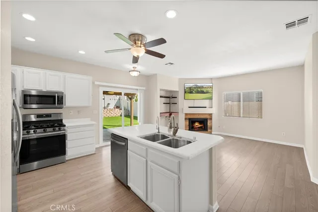 a kitchen with stainless steel appliances kitchen island granite countertop a stove a sink and a refrigerator