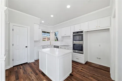 a kitchen with a sink and wooden floor