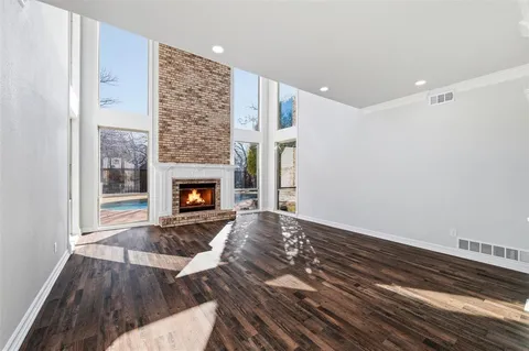 a view of empty room with wooden floor and fireplace