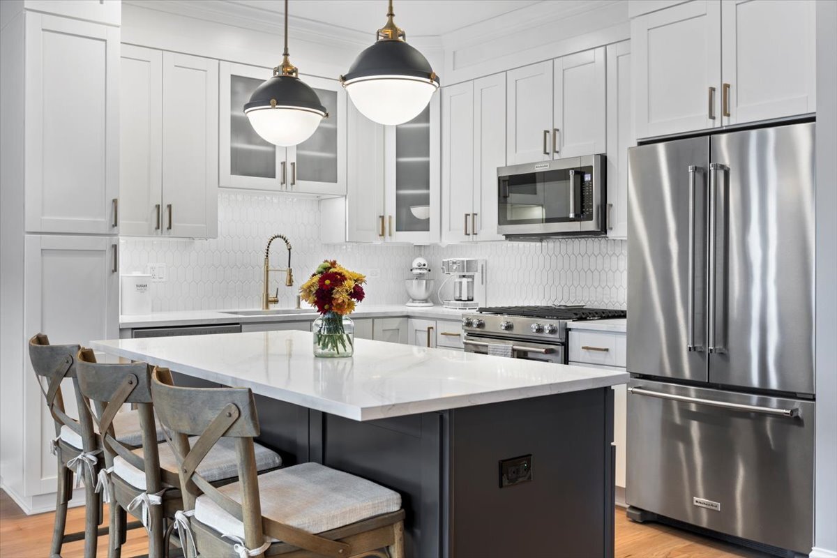 2463 West Foster Avenue, Unit 3 Chicago, IL 60625 - Photo 11 of 31 a kitchen with stainless steel appliances a dining table chairs refrigerator and microwave