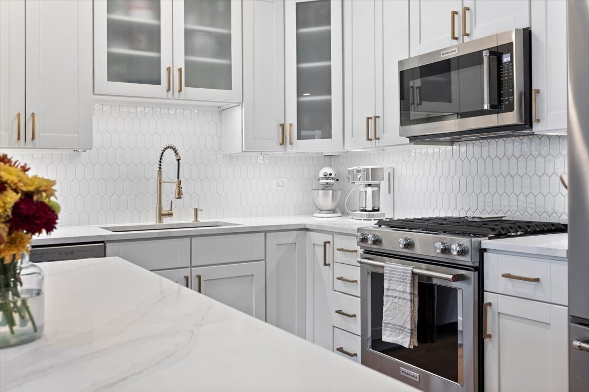 2463 West Foster Avenue, Unit 3 Chicago, IL 60625 - Photo 12 of 31 a kitchen with stainless steel appliances a stove microwave and cabinets