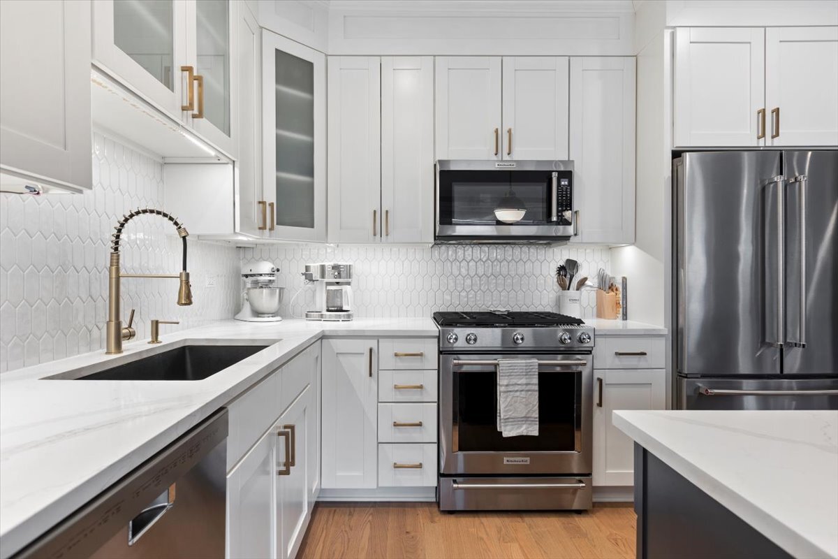 2463 West Foster Avenue, Unit 3 Chicago, IL 60625 - Photo 13 of 31 a kitchen with white cabinets and stainless steel appliances
