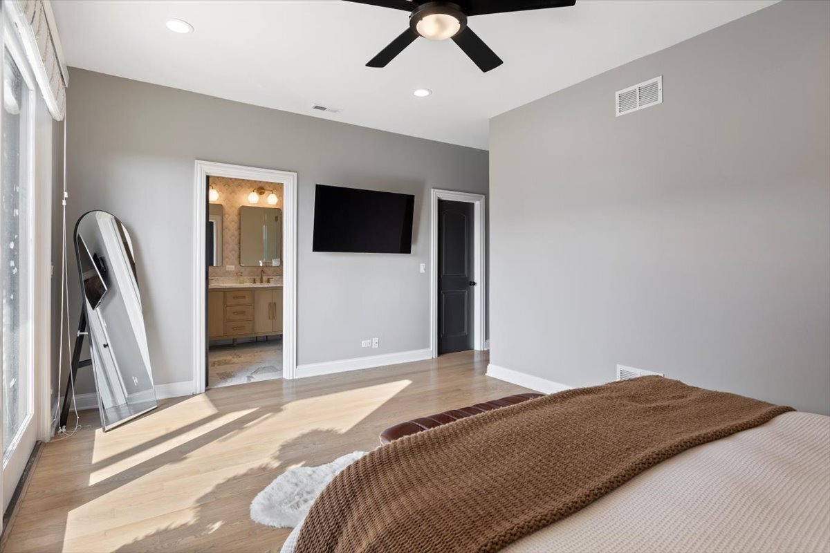 2463 West Foster Avenue, Unit 3 Chicago, IL 60625 - Photo 17 of 31 a bedroom with a bed and a flat screen tv