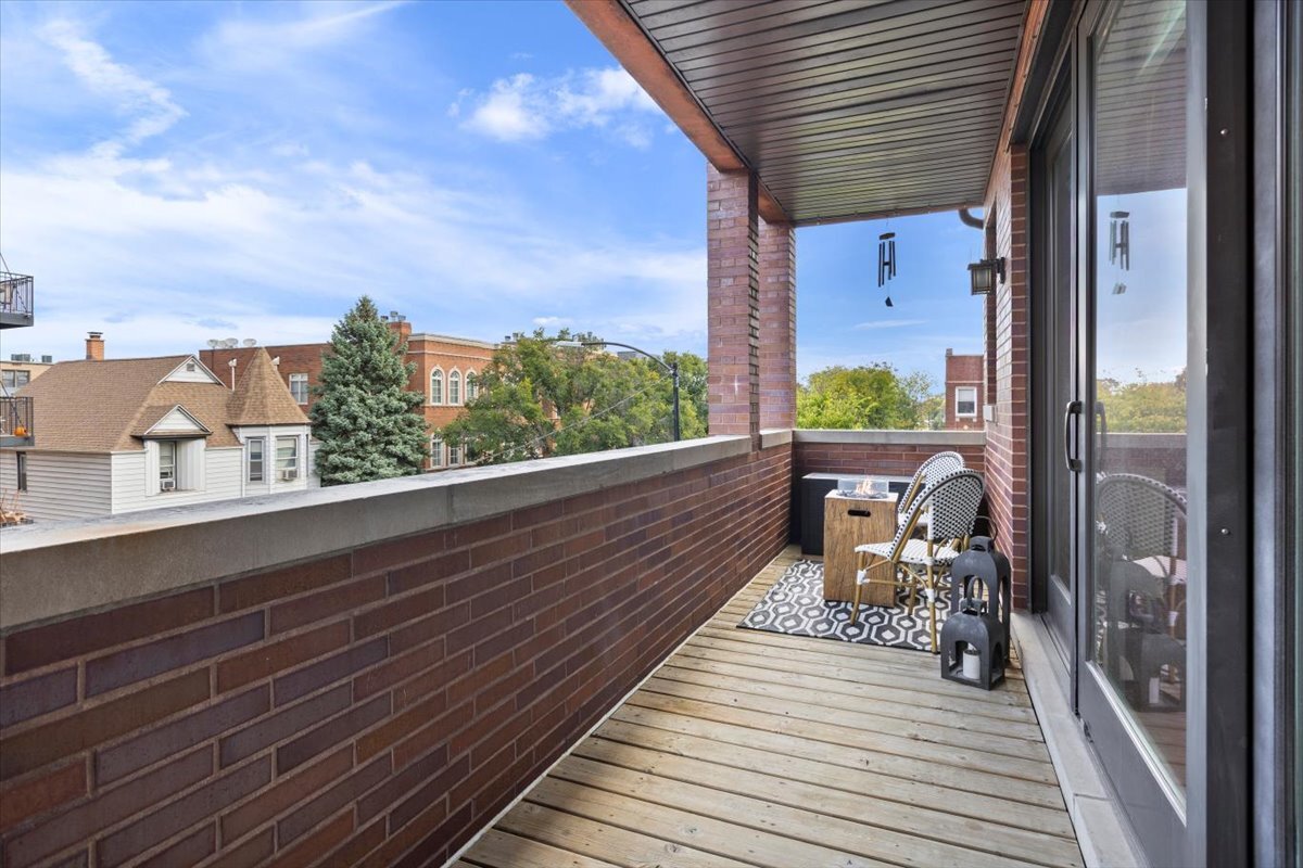 2463 West Foster Avenue, Unit 3 Chicago, IL 60625 - Photo 27 of 31 a view of a balcony with chairs and wooden floor
